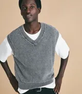 Chaleco masculino de punto color gris con efecto desteñido, corte boxy, cuello en V y barras contrastantes en el cuello y el dobladillo.