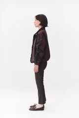 Campera de denim azul con corte oversized, cierre frontal y cuello de piel sintética marrón desmontable. Presenta detalles de volados en el frente, puños elásticos y logo bordado en el pecho.