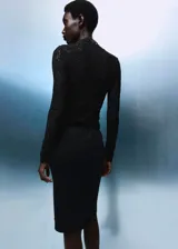 Top de encaje negro con cuello perkins, diseño entallado y manga larga.