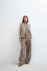 Chaqueta corta color marrón con cuello solapa y diseño con patchwork de telas. Manga larga con detalle de coderas aplicadas. Cierre frontal mediante botones y bolsillos ojal. Con forro.