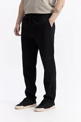 Pantalón de jogging color beige, confeccionado en algodón y poliéster, con cintura elástica y cordón ajustable. Diseño clásico sin puño en los tobillos.