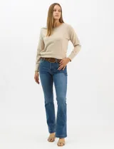 Jean de tiro alto con corte bootcut, color azul medio, con diseño de cinco bolsillos y costuras en contraste. Incluye un cinturón trenzado de cuero sintético con hebilla metálica.