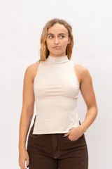Top sin mangas con cuello alto tipo polera, confeccionado en tela elástica, con diseño de espalda corta.
