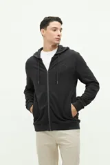 Campera de felpa color verde militar, con cierre frontal, capucha ajustable con cordones y logo estampado en el pecho.