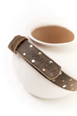 Cinturón negro de cuero con apliques de pelo animal print y hebilla metálica con el logo de la marca.