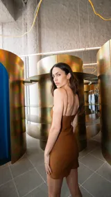 Vestido corto color marrón, confeccionado en bengalina lisa, de corte recto y breteles regulables.