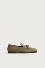 Mocasín de vestir para hombre, confeccionado en piel con acabado serraje de color tostado, con detalle de borlas en el empeine y suela de ligero tacón.