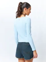 Remera blanca de algodón, de manga larga y cuello redondo.