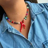 Collar corto de cuentas de colores con dije de coral rojo.