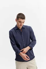 Camisa de manga larga color verde militar, con cuello tradicional y cierre frontal de botones.