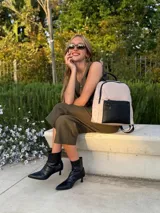 Mochila urbana de diseño combinado, confeccionada en tela resistente con bolsillo frontal y detalles en cuero sintético. Cuenta con compartimento principal con cierre y correas ajustables.