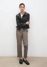 Pantalón de tiro medio color marrón con sutil diseño de raya diplomática, de corte entallado y diseño crop. Cuenta con bolsillos laterales, trabillas y cierre frontal con cremallera, botón y ganchos ocultos.