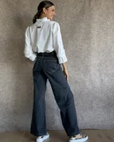 Pantalón de jean estilo wide leg con costuras verticales frontales, tiro alto y bolsillos laterales.