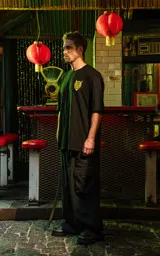 Remera negra de algodón con corte holgado y estampado frontal de un demonio con cuernos en color amarillo.