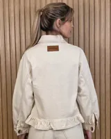 Sobrecamisa de pana color gris con diseño a rayas diagonales sutiles, cuello camisero, cierre frontal con botones, bolsillos aplicados al frente y detalle de volado en el ruedo.