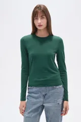 Remera verde esmeralda de manga larga, corte ajustado y cuello redondo.