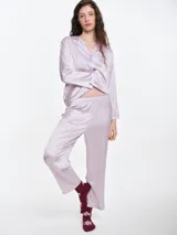 Pantalón de pijama de satén con caída fluida, corte recto y cintura elástica. Presenta un acabado suave y sedoso al tacto.