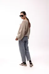 Saco tejido de punto color azul, con escote en V y cierre frontal mediante lazos. Presenta mangas largas amplias con puños ajustados y un calce relajado.