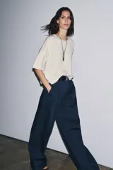 Jersey de punto color crema, confeccionado en 100% lana, con cuello redondo y mangas cortas anchas, de calce amplio.