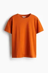 Remera oversized confeccionada en punto de algodón suave, de color naranja, con hombros levemente caídos, mangas cortas y cuello redondo ribeteado.