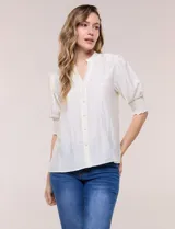 Blusa blanca de crepé con cuello mao y escote en V, cierre frontal con botones, mangas cortas abullonadas con puños elastizados en punto smock y calce semi holgado.