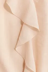 Blusa oversized de crepé en mezcla de viscosa y poliéster, color beige, con cuello redondo fruncido, escote en V con tirantes finos, mangas largas abullonadas con puños ajustados y volados decorativos en el frente.