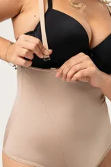 Faja abdominal color piel, cavada, reforzada en la zona abdominal, confeccionada en lycra. De contención media, cola bikini, con breteles desmontables regulables y broche en la entrepierna con fundillo de algodón.