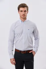 Camisa de manga larga con diseño de cuadros vichy en tono celeste y blanco, cuello abotonado y bolsillo frontal en el pecho con logo bordado.