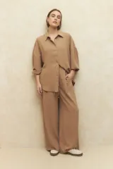 Camisa beige de manga larga con botones a tono.