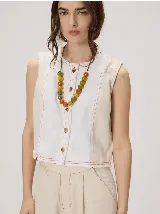 Collar regulable con tira de cuero y cuentas esféricas de cerámica en tonos verde, naranja y amarillo, con dije metálico colgante.