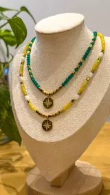 Collar de piedra natural ágata amarilla y cuentas de nácar, con detalles de hematita dorada y dije circular de acero con estrella grabada y cristales.