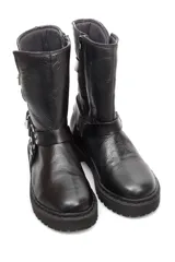 Bota de caña media confeccionada en cuero negro, con suela track dentada. Presenta un diseño con dos correas ajustables con hebillas metálicas y un detalle de argolla metálica en la parte inferior, además de cierre lateral.