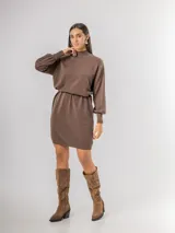 Vestido tipo polerón de tejido de punto color borgoña, con cuello alto, mangas largas con puños ajustados y corte recto. Incluye un cinturón del mismo material con una hebilla decorativa de flor con cristales.