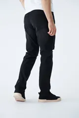 Jean de corte recto en color azul claro, con diseño de tiro medio y cintura regular. Presenta detalles de roturas en las rodillas y logo bordado en el bolsillo pequeño delantero.