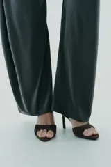 Sandalia tipo mule de tacón alto fino, color marrón oscuro, con capellada de serraje y punta cuadrada.