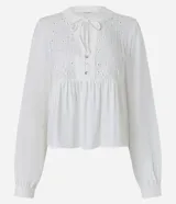 Blusa tipo bata de color celeste con mangas largas y cuello mao con lazo. Presenta detalles de bordado floral calado tipo laise en el frente y cierre parcial con botones.