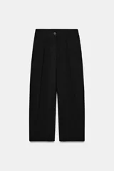Pantalón de corte carrot con pinzas delanteras, tiro bajo y cierre frontal con cremallera y botón. Cuenta con bolsillos laterales y falsos bolsillos traseros de vivo.