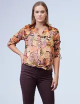 Blusa de gasa estampada marca Figueroa & Flower. Tiene cuello a la base, escote en V y abertura central con botones. El largo de la manga es regulable con presilla y botón. La terminación del ruedo es anudada opcional. Incluye musculosa interna.