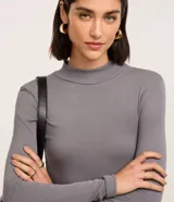 Blusa Cortelle de manga larga y cuello alto, confeccionada en tejido rib de viscosa elastizada en color gris.
