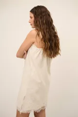 Top celeste con tirantes finos y detalles de encaje marrón en el escote y el dobladillo inferior.