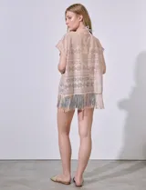 Kaftan blanco calado con cuello a la base, escote en V y lazo de ajuste. Terminación de ruedo con flecos.