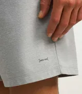 Bermuda deportiva gris de poliéster con cintura elástica y cordón interno ajustable. Cuenta con un bolsillo trasero funcional con cierre de cremallera.