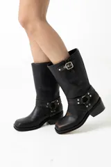 Botas de cuero negro de caña media, con punta cuadrada, taco bajo y detalles de correas con hebillas y tachas.