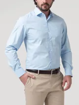 Camisa de manga larga RKF modelo Easysolid, color celeste, confeccionada en popelina de algodón, con cuello clásico, cierre frontal de botones y bolsillo en el pecho con logo bordado.