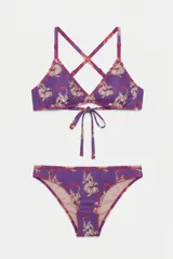 Conjunto de bikini violeta con estampado de dragones, compuesto por un corpiño triangular con tiras cruzadas en la espalda y cordón para atar en el centro, y una bombacha clásica tipo vedetina.