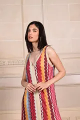 Vestido largo de punto con diseño de rayas verticales en zigzag, escote en V y espalda baja. Presenta detalles de vivos en hilo metalizado lurex.