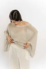 Blusa color beige de hilo con mangas amplias y terminación en picos.