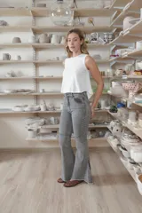 Jean oxford de tiro alto en color azul, con cortes horizontales y diagonales en las rodillas y detalles desflecados en el ruedo.