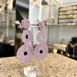 Aros colgantes con forma de círculos tramados con cristales color lila.