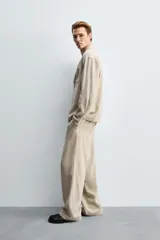 Pantalón de corte relaxed fit confeccionado en una mezcla de lyocell y lino. Presenta bolsillos frontales, bolsillos traseros de vivo y cierre frontal con cremallera y botón.